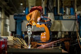 Robot is welding metal part in automotive industrial